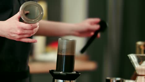 Barista-bereitet-schwarzen-Kaffee-mit-dem-aeropress