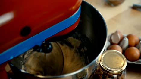 Close-up-view-of-female-hands-turns-on-the-mixer.-Young-woman-cooking-the-dough-in-the-bown-on-the-kitchen