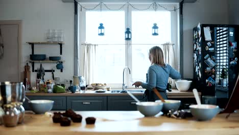 Junge-schöne-Frau,-waschen-die-Schüssel-nach-dem-Backen-die-Muffins.-Blonde-Frau,-die-Reinigung-der-Küche-nach-dem-Kochen