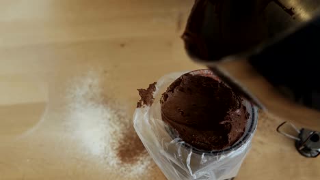 Close-up-view-of-female-hands-putting-the-chocolate-cream-or-dough-into-the-pastry-bag.-Woman-cooking-in-the-kitchen