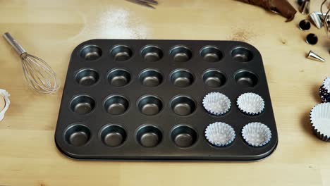 Detener-el-movimiento.-Vasos-de-papel,-envolturas-para-cupcakes-en-la-bandeja-para-muffins.-Cocinar-en-la-cocina