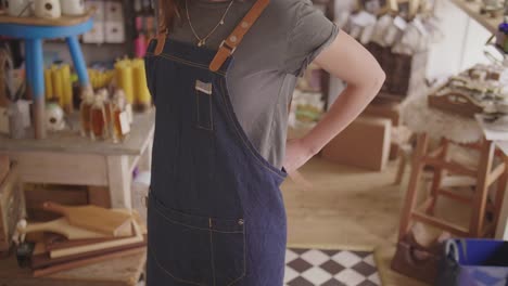 Midsection-Of-Small-Business-Owner-Wearing-Denim-Apron-In-Store