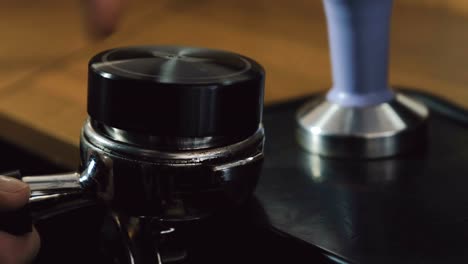 Barista-using-coffee-tamper-for-espresso