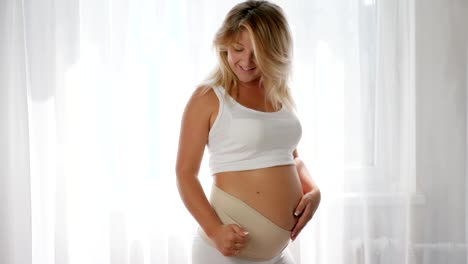 close-up-of-girl-posing-on-the-camera-in-a-bandage-for-the-comfort-of-pregnant-women