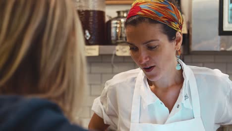 Young-woman-serving-a-customer-at-a-butcher's-shop,-close-up