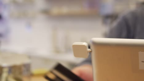 Woman-making-a-card-payment-on-a-touch-screen-till-at-a-shop