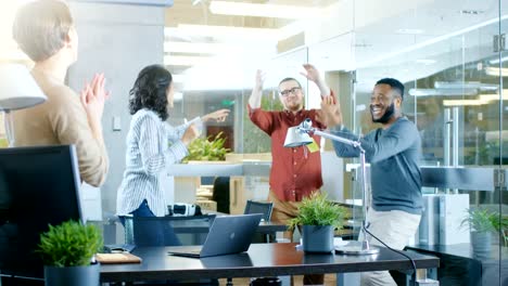 Diverse-Group-of-Young-Women-and-Men-Dance-and-Have-Fun-in-the-Modern-Office.-Black-Young-Man-Spins-Beautiful-Hispanic-Woman.