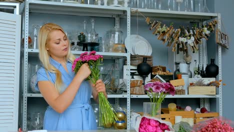 Professional-florist-preparing-pink-turkish-carnation-for-bouquet-at-workshop