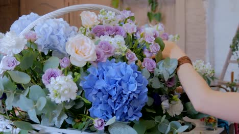 Florist-making-large-floral-basket-with-flowers-at-flower-shop