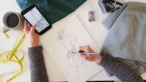 Overhead-view-of-woman-sketching-fashion-designs