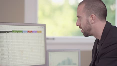 Close-up-of-a-business-man-in-a-bright-office-entering-data-into-a-computer