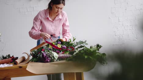 Weibliche-Floristen-wickeln-einen-Blumenstrauß