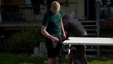 Vater-und-Sohn-reparieren-die-Innentüren-im-Garten-an-der-frischen-Luft