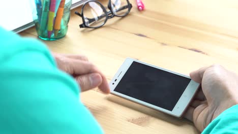 Businessman-in-Green-T-Shirt-Slide-Zoom-Touch-Horizontal-Smartphone-in-Home-Office