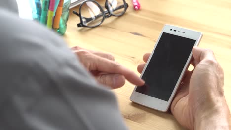 Businessman-in-Grey-Shirt-Slide-Zoom-Touch-Smartphone-in-Home-Office