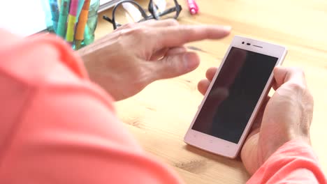 Geschäftsmann-in-Orange-T-Shirt-Folie-Zoom-Touch-Smartphone-im-Home-Office