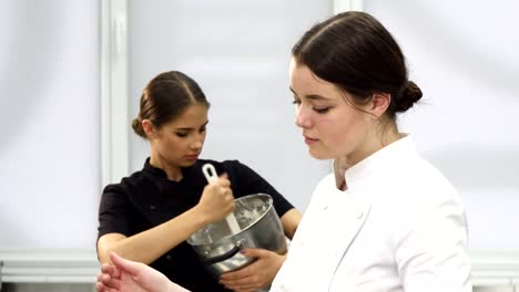 Young-attractive-female-chef-smiling-to-the-camera-while-cooking