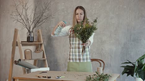 Florist-watering-flower-bouquet-at-flower-shop