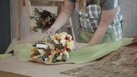 Weibliche-Hände-wickelte-essbaren-Blumenstrauß-in-Kraftpapier