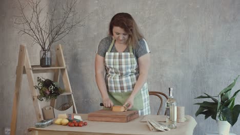 Schöne-Frau-schneiden-leckeren-Käse-an-Bord