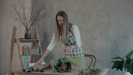 Smiling-florist-arranging-flower-bouquet-at-workplace