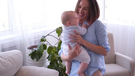 Mother-with-little-baby-dancing-in-living-room