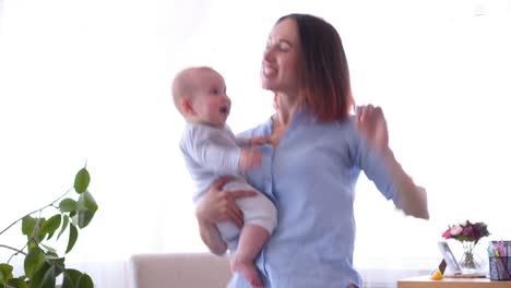 Cheerful-girl-playing-with-little-baby-dancing-together