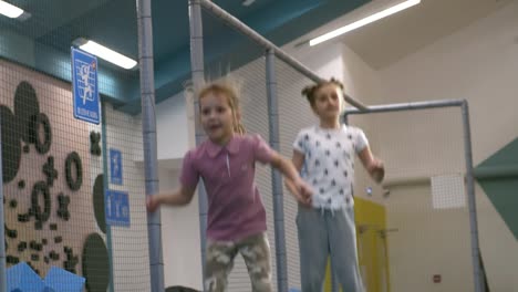 Zwei-Mädchen-auf-Indoor-Trampolin-Springen