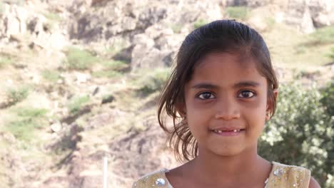 Little-cute-Indian-girl-watching-something-and-getting-frightened-but-happy-and-smiling-still