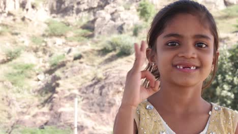 Little-cute-Indian-girl-making-hand-gestures-towards-the-camera-sayng-good-or-ok