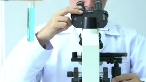 Male-scientists-looking-through-microscope-and-observe-in-modern-laboratory-or-medical-center.-Concept-of-science,-testing-development-and-lab-industry.