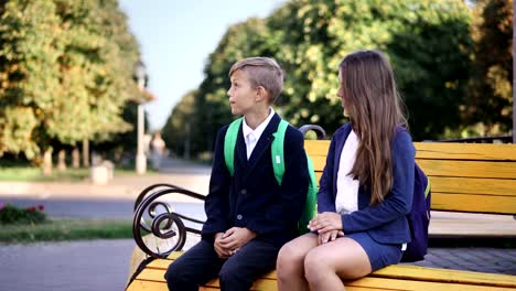 Young-boy-and-girl-are-sitting-on-the-bench