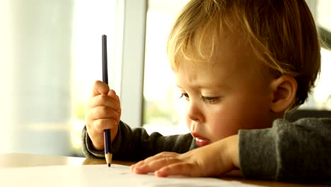 Baby-boy-draws-with-a-pencil