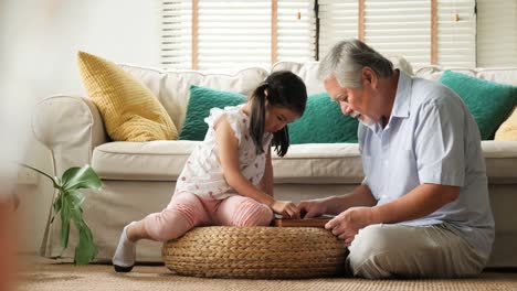 Senior-hombre-y-niña-jugando-juntos-en-casa.-Concepto-de-familia-estilo-de-vida-superior.