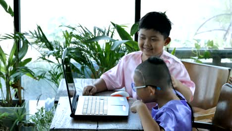 Glückliche-kleine-asiatische-junge-zwei-Menschen-mit-Computer-Laptop.