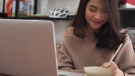 Cámara-lenta-de-la-chica-escribiendo-en-el-ordenador-portátil.-Mujer-modelo-lindo-Tailandia-usando-el-portátil-con-cara-de-sonrisa.