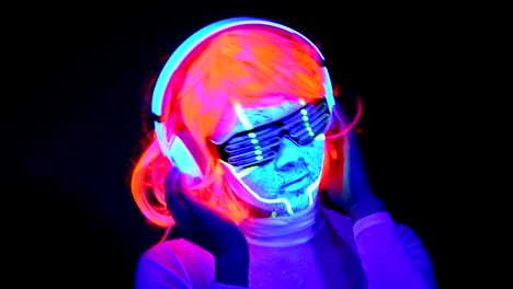 Mujer-con-pintura-Ultravioleta-de-la-cara-de-cyborg,-peluca,-brillantes-gafas,-ropa-bailando-y-escuchando-música-con-auriculares.-Mujer-asiática.-.