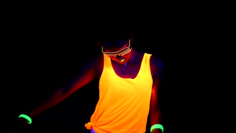 Woman-with-UV-face-paint,-glowing-clothing,-glowing-glasses,-bracelet-dancing-in-front-of-camera,-half-body-shot.-Asian-woman.-.