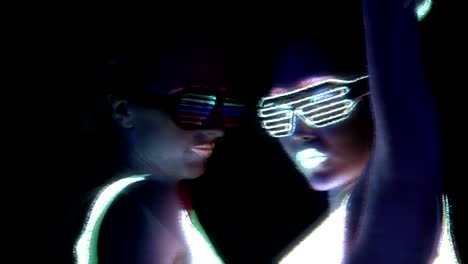 Women-with-UV-face-paint,-glowing-clothing,-glowing-bracelet,-glasses-dancing-in-front-of-camera,-face-shot.-Caucasian-and-woman.-Glitch-effects.-Women.