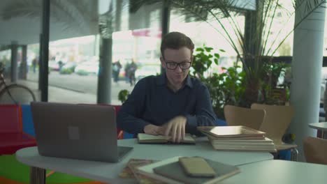 Young-man-is-searching-information-in-the-book-in-the-library