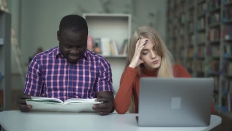 Interracial-students-leafing-through-a-book