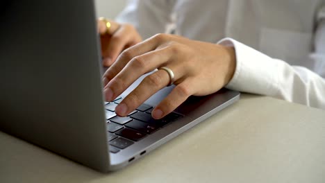 Young-businessman-typing-on-laptop-keyboard-in-office.