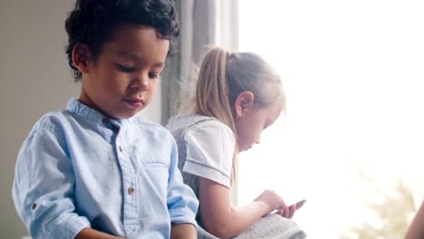 African-Boy-and-Caucasian-Girl-Playing-on-Smartphones