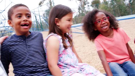 Elementary-school-kids-spinning-in-a-playground,-close-up