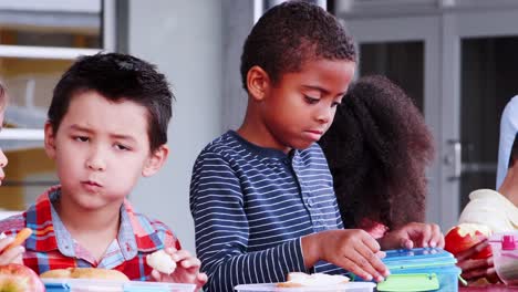 Grundschule-Kinder-und-Lehrer-an-einem-Tisch-in-der-Mittagspause