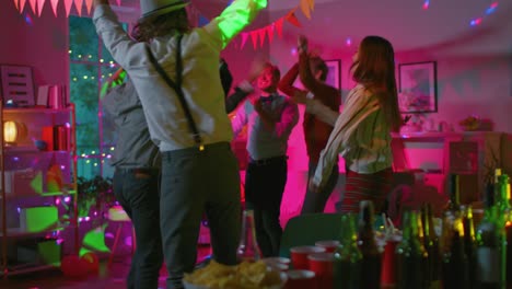 At-the-College-House-Costume-Party:-Diverse-Group-of-Friends-Have-Fun,-Dancing-and-Socializing.-Stylish-Boys-and-Girls-Dance-in-the-Living-Room.-Disco-Neon-Strobe-Lights-Illuminating-Room.