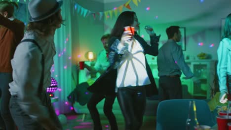 At-the-College-House-Costume-Party:-Diverse-Group-of-Friends-Have-Fun,-Dancing-and-Socializing-and-Drinking.-Stylish-Boys-and-Girls-Dance-in-the-Living-Room.-Girl-Pours-Herself-Drink-into-Red-Cup.