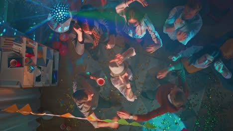 At-the-College-Party:-Diverse-Group-of-Friends-Have-Fun,-Dance,-Socialize-and-Drink.-Stylish-Young-People-Dance-Energetically-in-the-Living-Room.-Disco-Neon-Lights.-Top-Down-Shot.