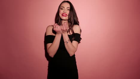 Brunette-happy-woman-drop-her-presents-on-the-ground-with-confetti-in-pink-background-wear-black-dress