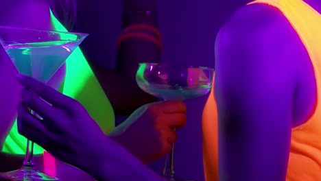 Langsame-Motin-von-schönen-sexy-Frauen-mit-fluoreszierenden-Make-up-und-Kleidung-Tanz-im-Neonlicht.-Night-Club,-Party-Konzept.